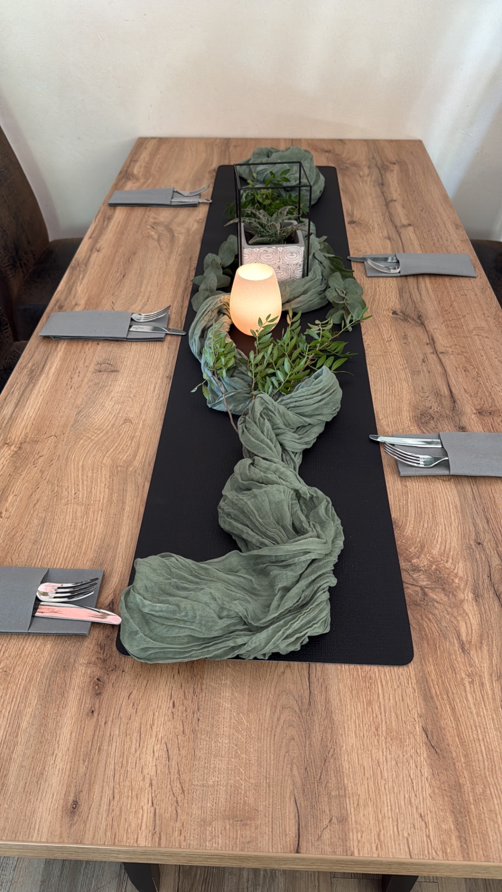 Tafel mit grünem Tischläufer, Eukalyptus und Windlicht