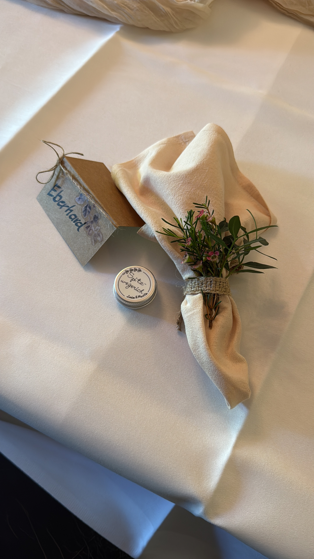 Serviette mit Kräuterbund, Namenskarte und kleinem Gastgeschenk