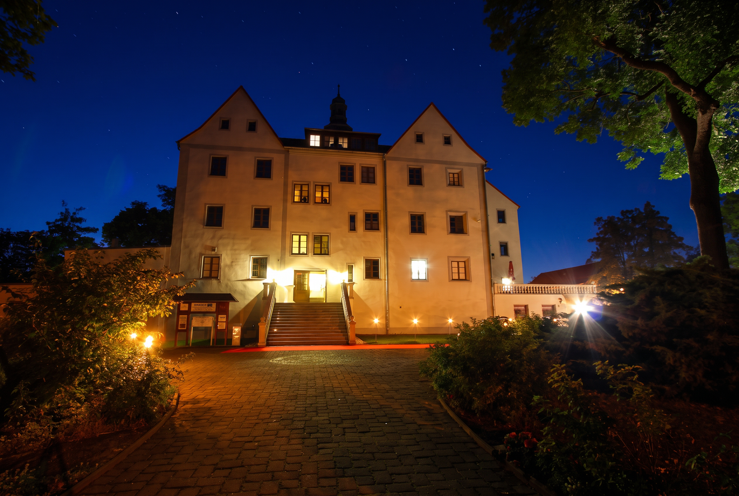 Rittergut Schenkenberg am Abend, beleuchtete Freitreppe und angestrahlte Fassade